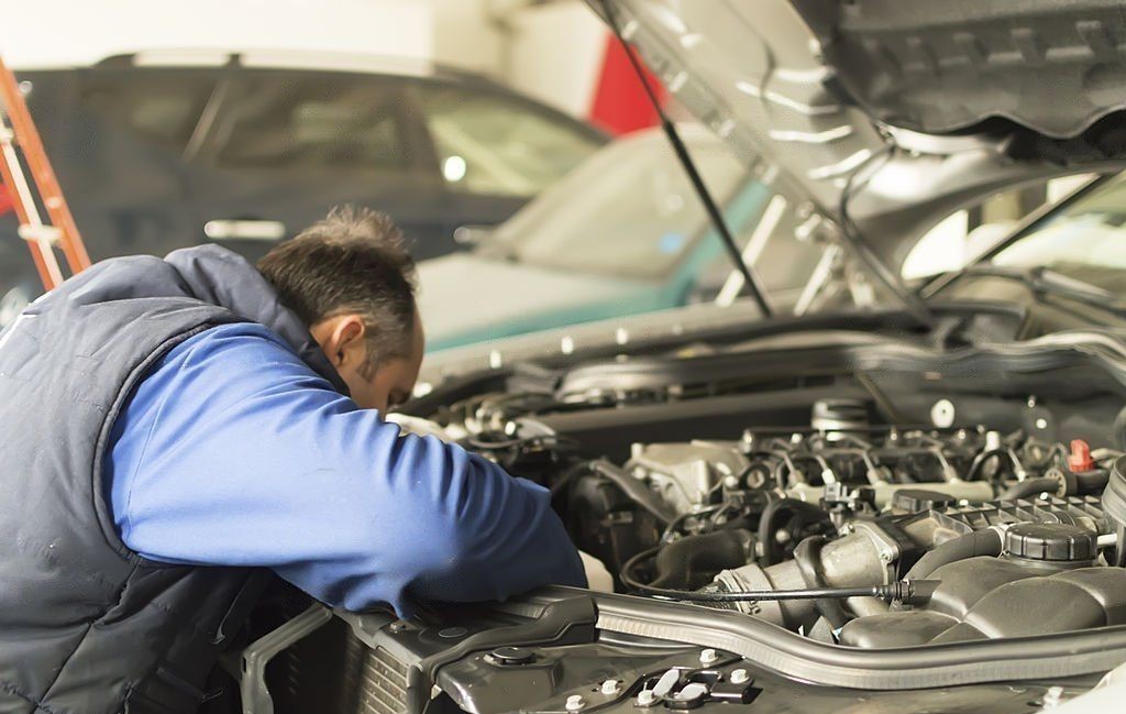 a mechanic repairing chrysler car engine